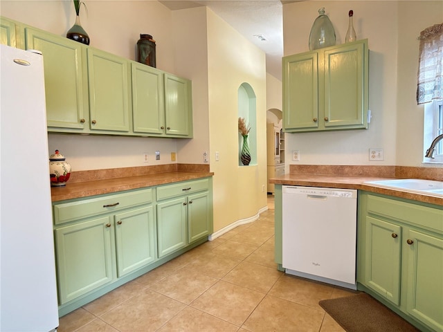 kitchen with light tile patterned flooring, white appliances, green cabinetry, and sink