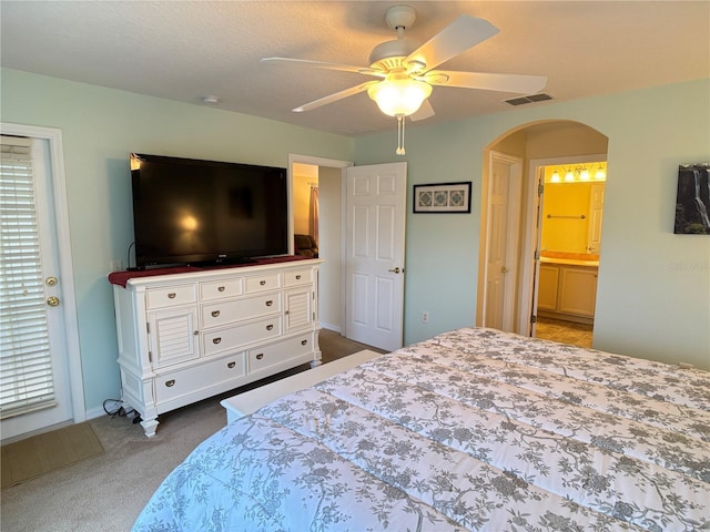 carpeted bedroom with connected bathroom and ceiling fan