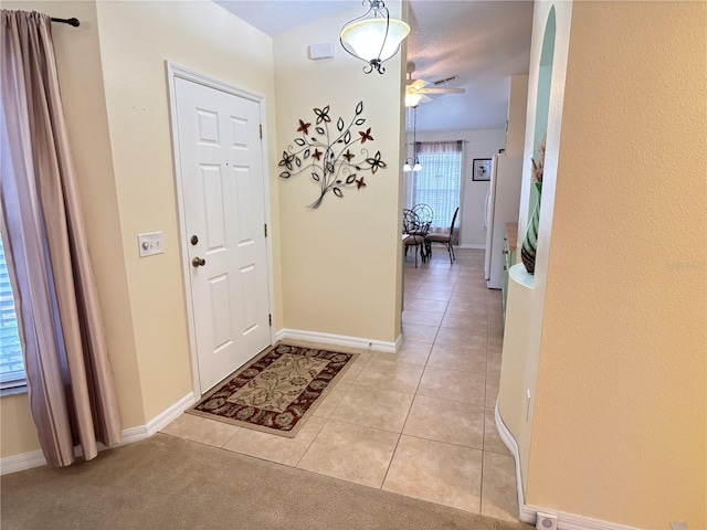 entryway with ceiling fan and light tile patterned floors