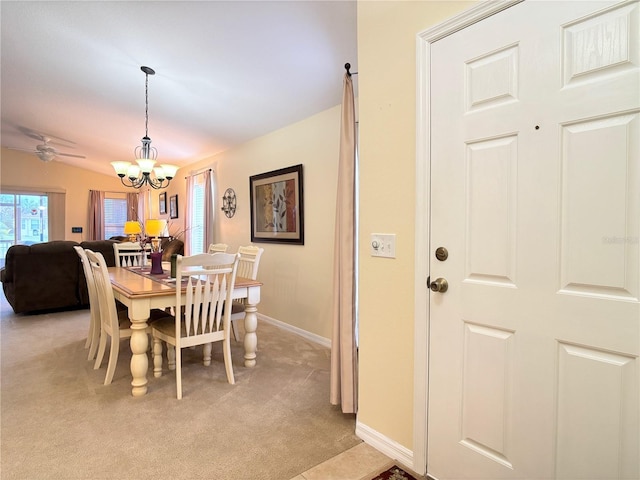 carpeted dining room featuring lofted ceiling and ceiling fan with notable chandelier