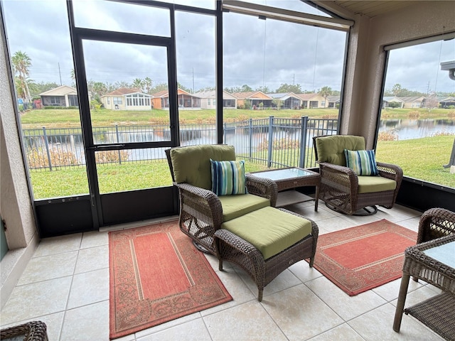 sunroom featuring a wealth of natural light and a water view