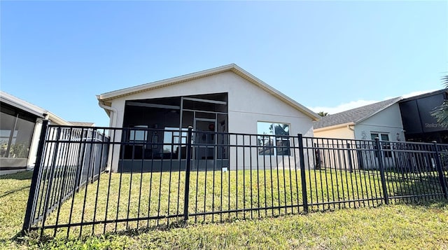 back of property featuring a lawn and a sunroom