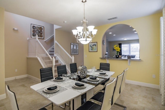 tiled dining space with an inviting chandelier