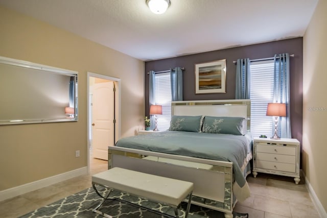 bedroom with light tile patterned floors and multiple windows