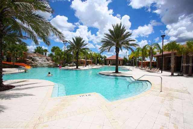 view of pool with a patio area and a water slide