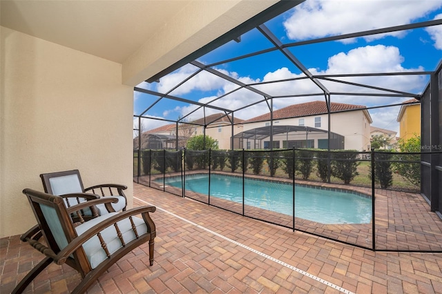 view of swimming pool featuring glass enclosure and a patio