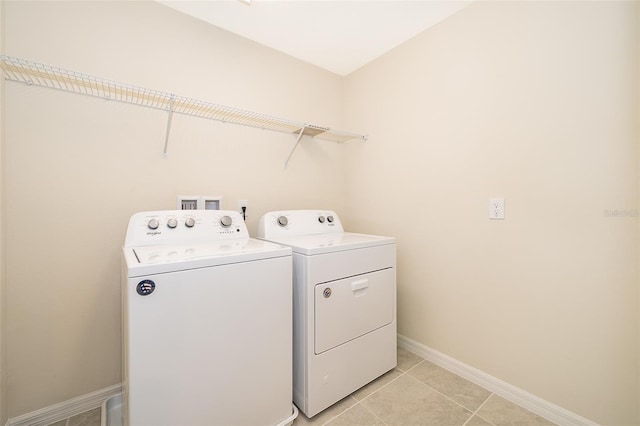 laundry area featuring washer and clothes dryer and light tile patterned flooring