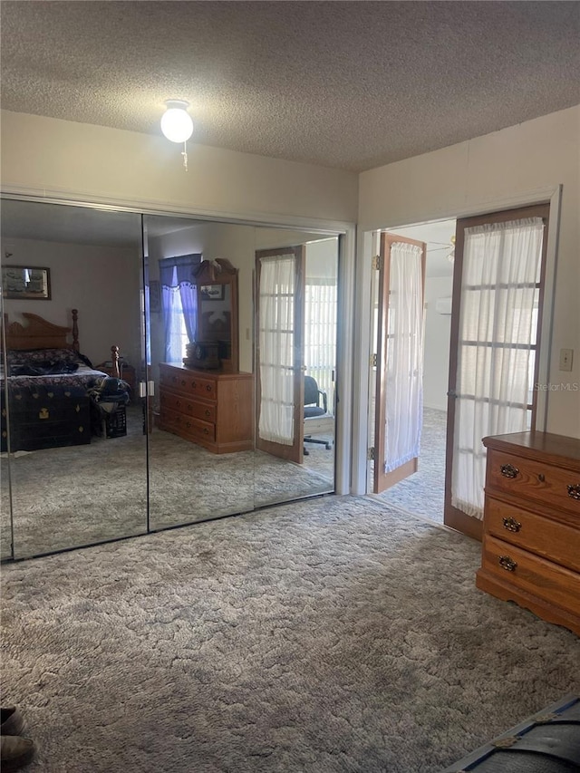 bedroom featuring carpet, french doors, a textured ceiling, and a closet