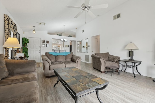 living room with hardwood / wood-style flooring, ceiling fan with notable chandelier, and lofted ceiling