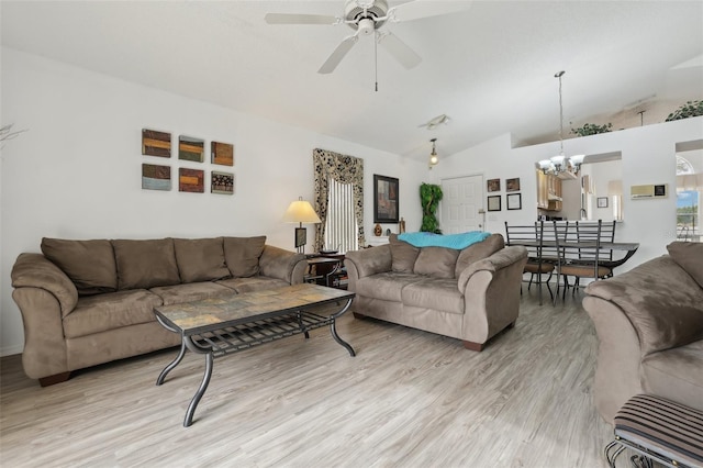 living room featuring ceiling fan with notable chandelier, light hardwood / wood-style floors, and vaulted ceiling