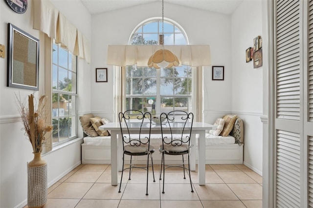 dining space featuring a healthy amount of sunlight, light tile patterned floors, and vaulted ceiling