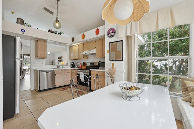 kitchen featuring sink, a healthy amount of sunlight, stainless steel appliances, decorative light fixtures, and light tile patterned floors