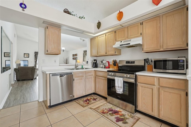 kitchen with light brown cabinets, sink, light tile patterned floors, and stainless steel appliances