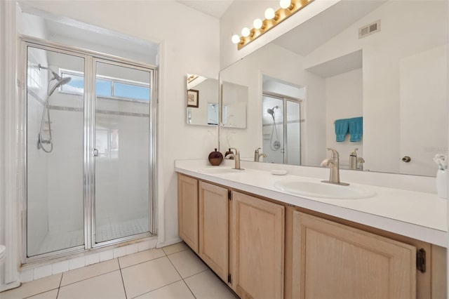 bathroom with tile patterned floors, vanity, a shower with shower door, and vaulted ceiling