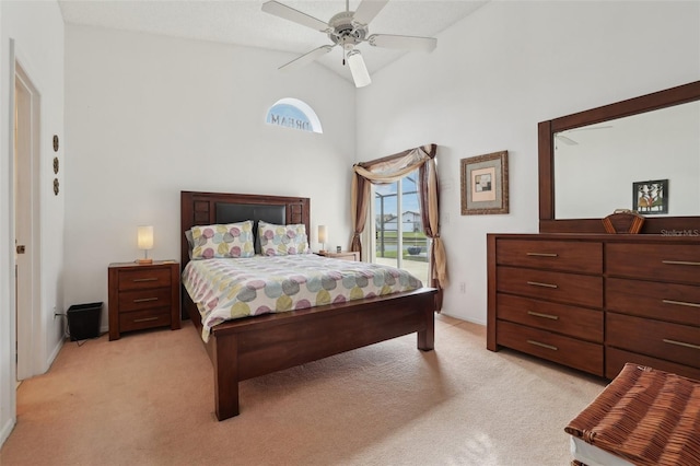 bedroom with ceiling fan, light colored carpet, and high vaulted ceiling