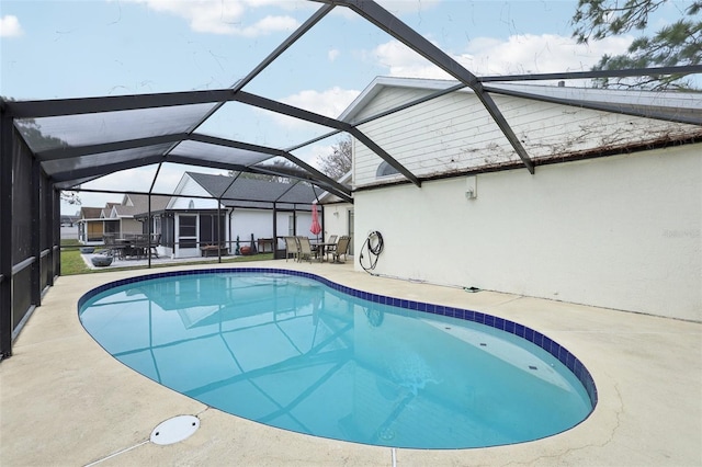 view of pool with glass enclosure and a patio