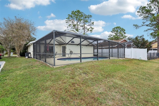 back of property with a fenced in pool, a lanai, and a lawn