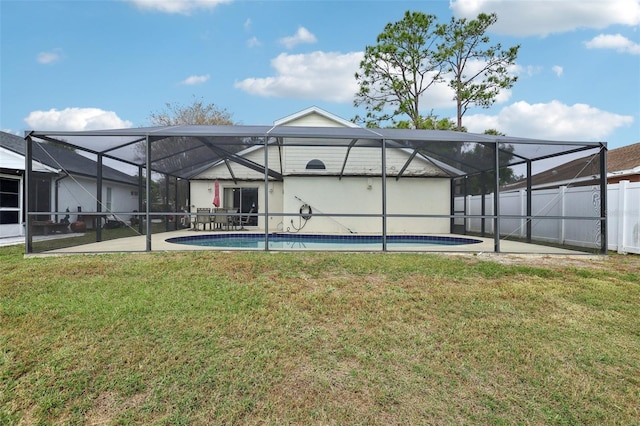 back of house featuring a lawn, glass enclosure, a patio area, and a fenced in pool