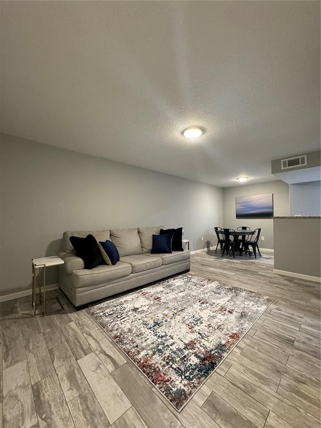 living room featuring wood-type flooring and a textured ceiling