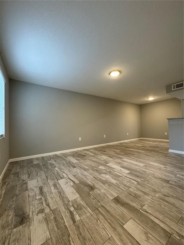 unfurnished room featuring a textured ceiling and wood-type flooring