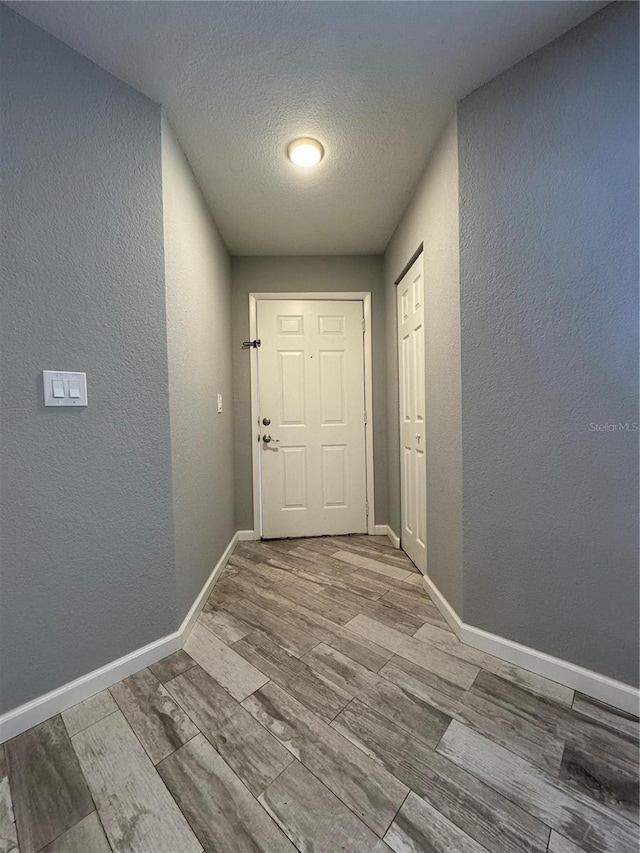 doorway to outside with a textured ceiling