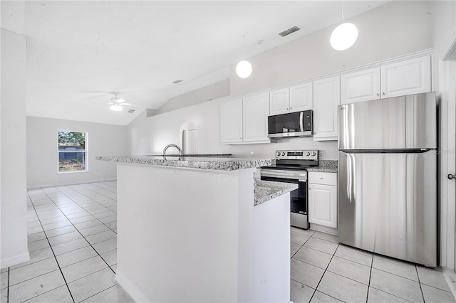 kitchen with ceiling fan, white cabinetry, vaulted ceiling, light tile patterned floors, and appliances with stainless steel finishes