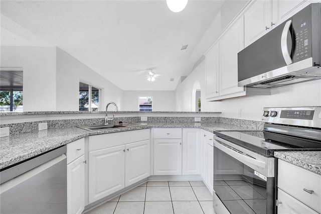 kitchen with stainless steel appliances, ceiling fan, sink, white cabinetry, and light tile patterned flooring