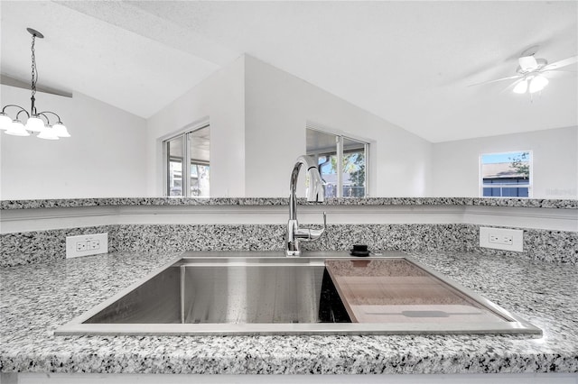 room details featuring a textured ceiling, ceiling fan with notable chandelier, sink, and hanging light fixtures