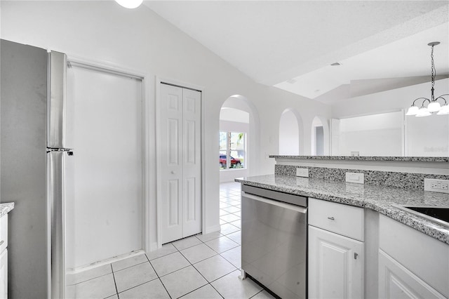 kitchen featuring white cabinets, pendant lighting, lofted ceiling, light tile patterned floors, and appliances with stainless steel finishes