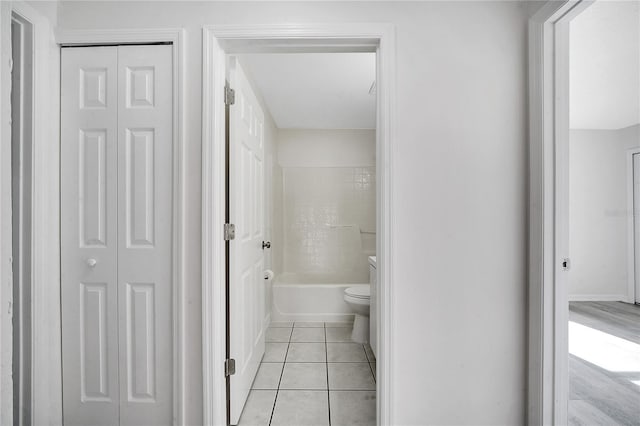 bathroom featuring tile patterned flooring, bathtub / shower combination, and toilet