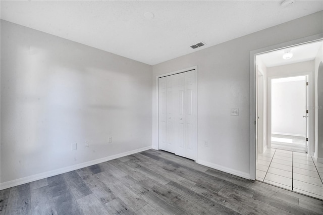 unfurnished bedroom with hardwood / wood-style flooring and a closet