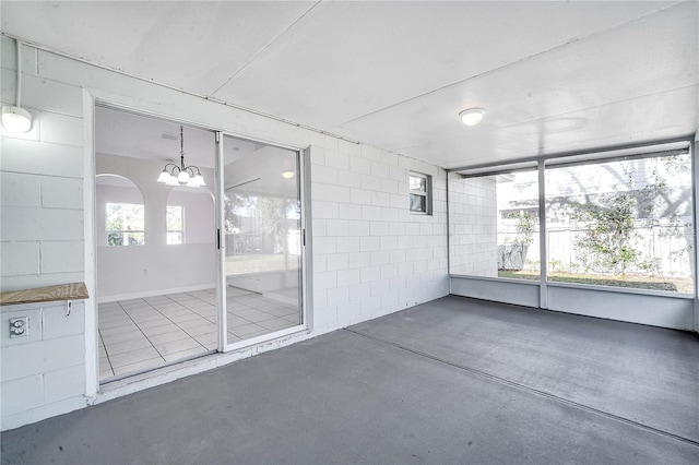 unfurnished sunroom with an inviting chandelier and a healthy amount of sunlight