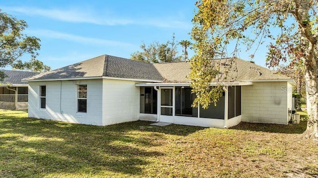 rear view of property with a lawn and a sunroom