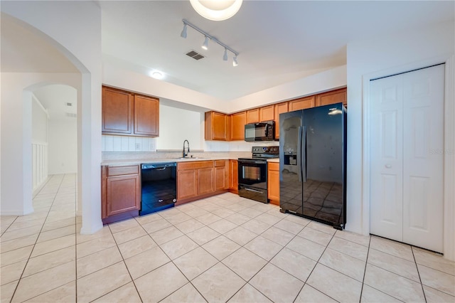 kitchen featuring light tile patterned floors, sink, and black appliances