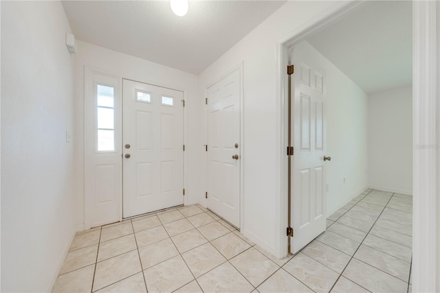 foyer entrance featuring light tile patterned flooring and a textured ceiling