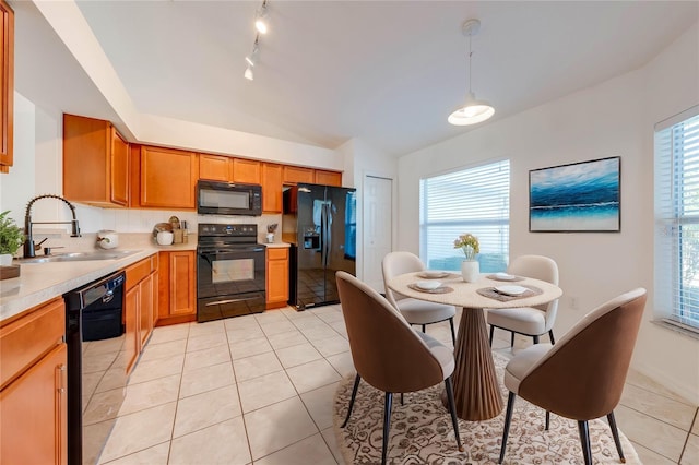 kitchen with sink, a healthy amount of sunlight, pendant lighting, light tile patterned floors, and black appliances