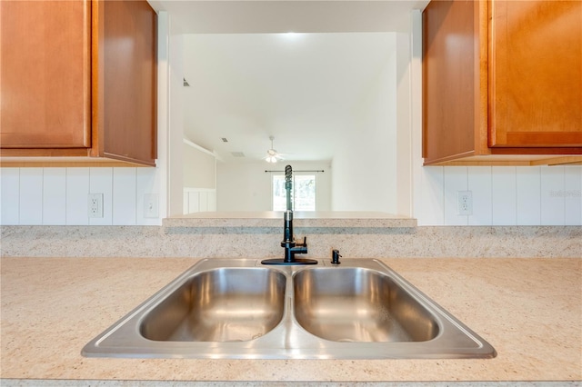 details with ceiling fan, sink, and tasteful backsplash