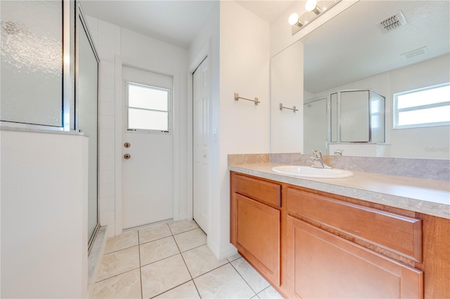 bathroom featuring tile patterned flooring, vanity, and walk in shower