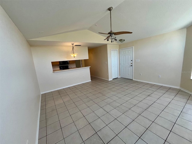 unfurnished living room with ceiling fan, light tile patterned floors, and vaulted ceiling