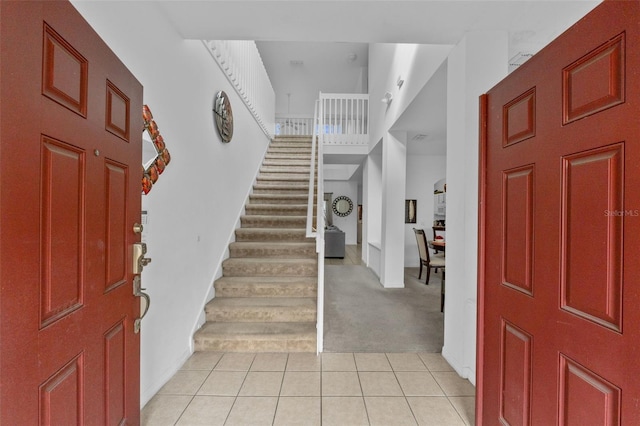 256 Lancaster Dr, Davenport, FL 33897 - foyer entrance with light tile patterned flooring, light carpet, and stairs