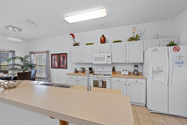 kitchen with white appliances, sink, a textured ceiling, light tile patterned flooring, and white cabinetry