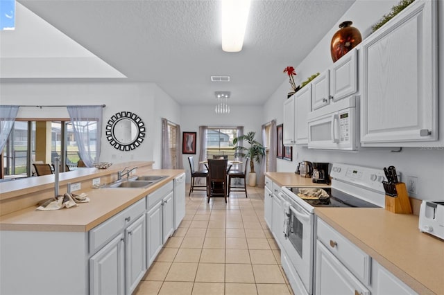 256 Lancaster Dr, Davenport, FL 33897 - kitchen featuring white appliances, light tile patterned flooring, a textured ceiling, light countertops, and white cabinets