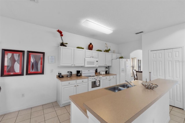 256 Lancaster Dr, Davenport, FL 33897 - kitchen featuring white appliances, arched walkways, white cabinets, light tile patterned flooring, and an island with sink