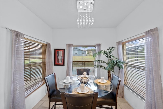 tiled dining area with a wealth of natural light and a notable chandelier