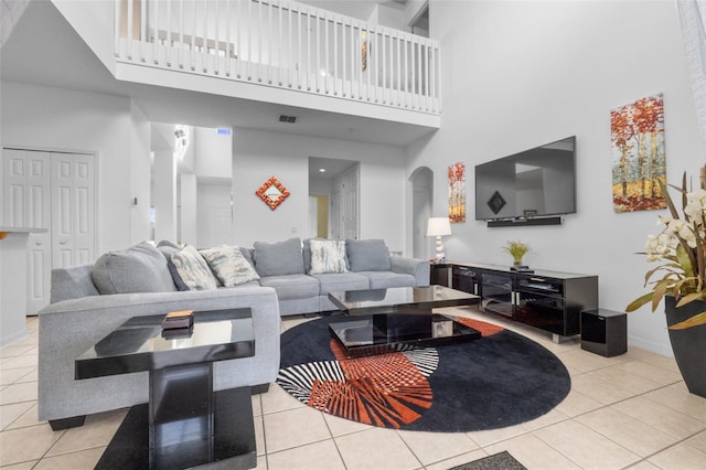 tiled living room featuring a high ceiling