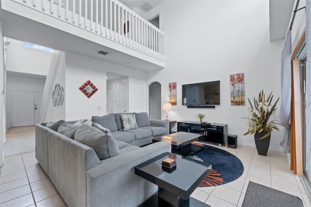 tiled living room featuring a towering ceiling