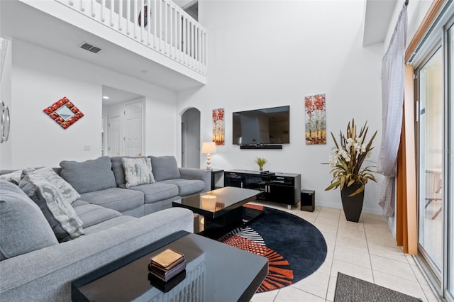 living room featuring light tile patterned floors and a high ceiling