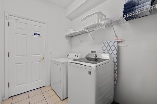 laundry room featuring washing machine and dryer and light tile patterned floors