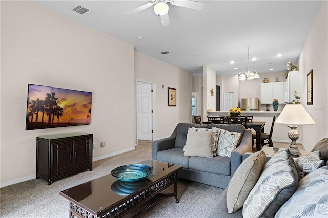 carpeted living room with ceiling fan with notable chandelier