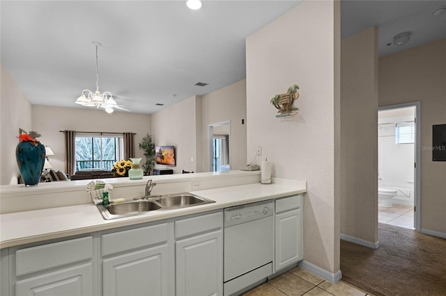 kitchen featuring dishwasher, sink, kitchen peninsula, light tile patterned floors, and white cabinetry